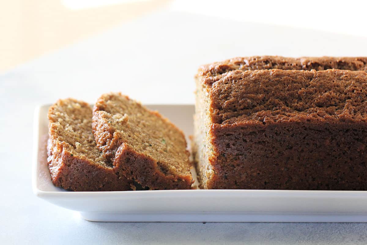 The Best Zucchini Bread Recipe on a white serving plate sliced