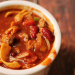 slow cooker chili in small serving bowl with melted cheese