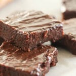 2 Fudgy Brownies stacked on a white plate.
