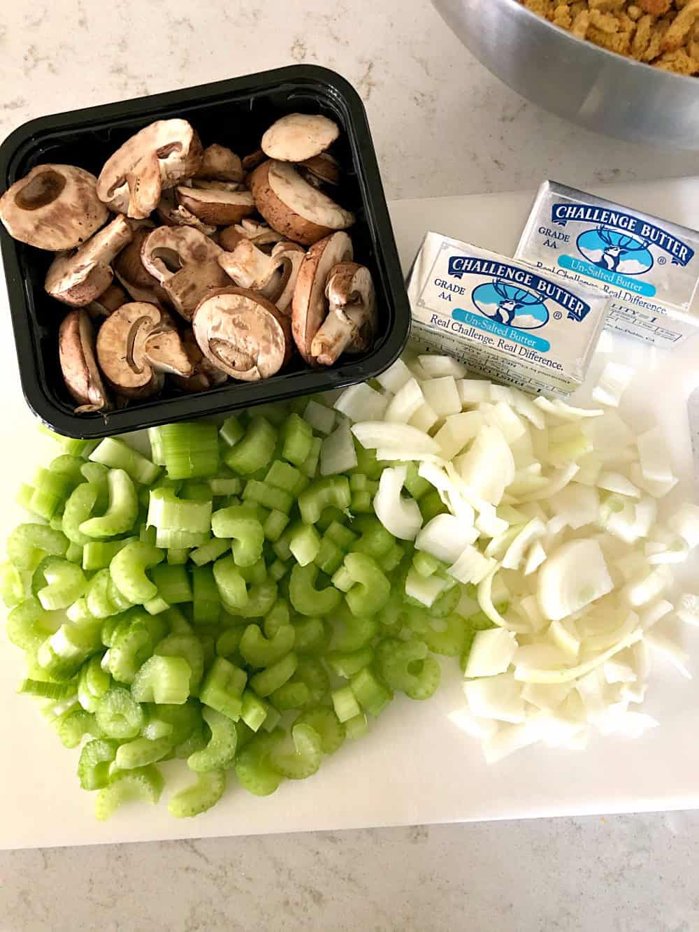 Ingredients for slow cooker stuffing: mushrooms, butter, cubed bread, chopped celery, onions