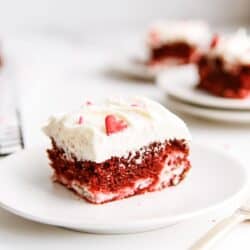 A slice of Red Velvet Cheesecake Swirl Cake on a white dish.