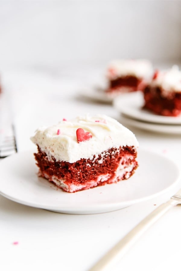 A slice of Red Velvet Cheesecake Swirl Cake on a white dish.