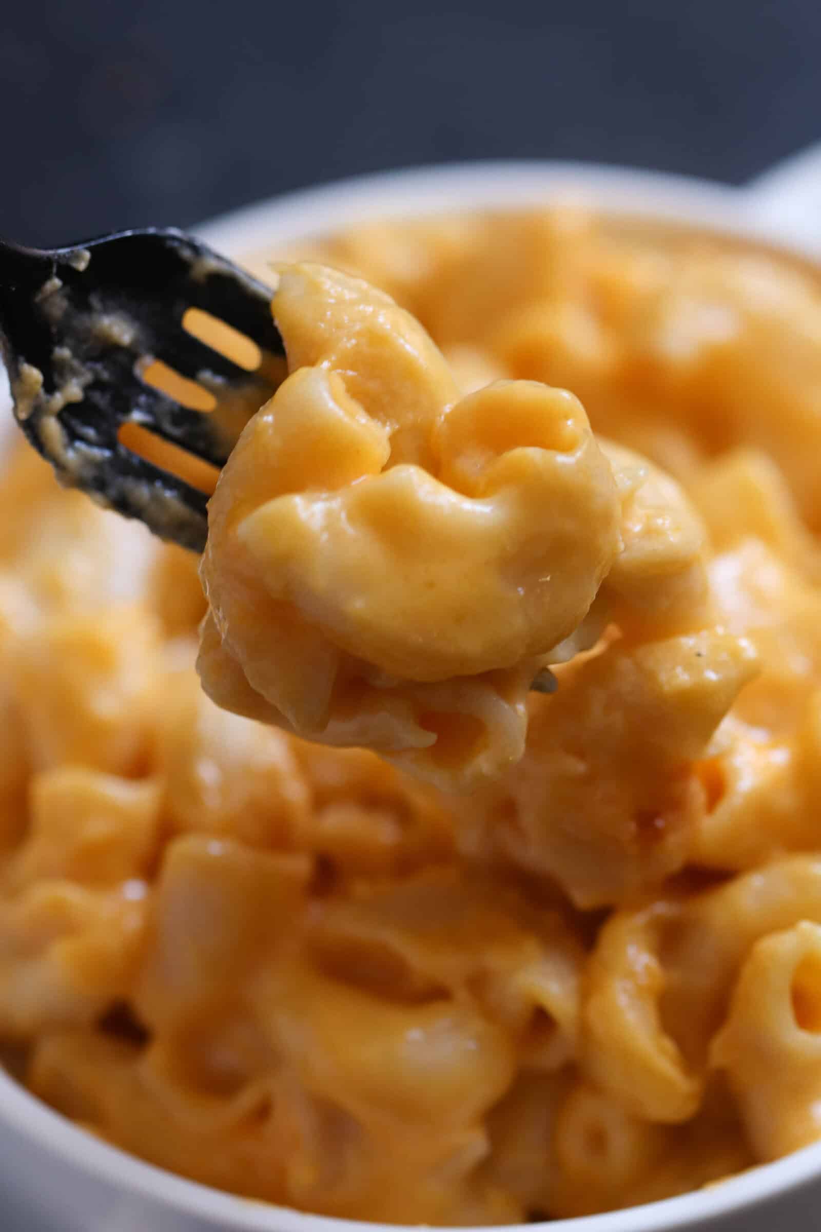 cheesy macaroni and cheese bite with a fork