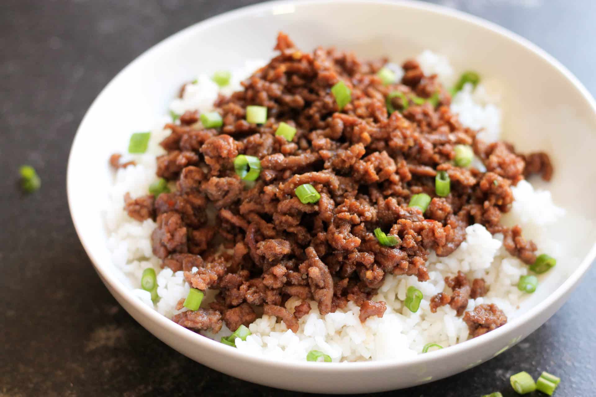 Korean Beef served over white rice in a white bowl