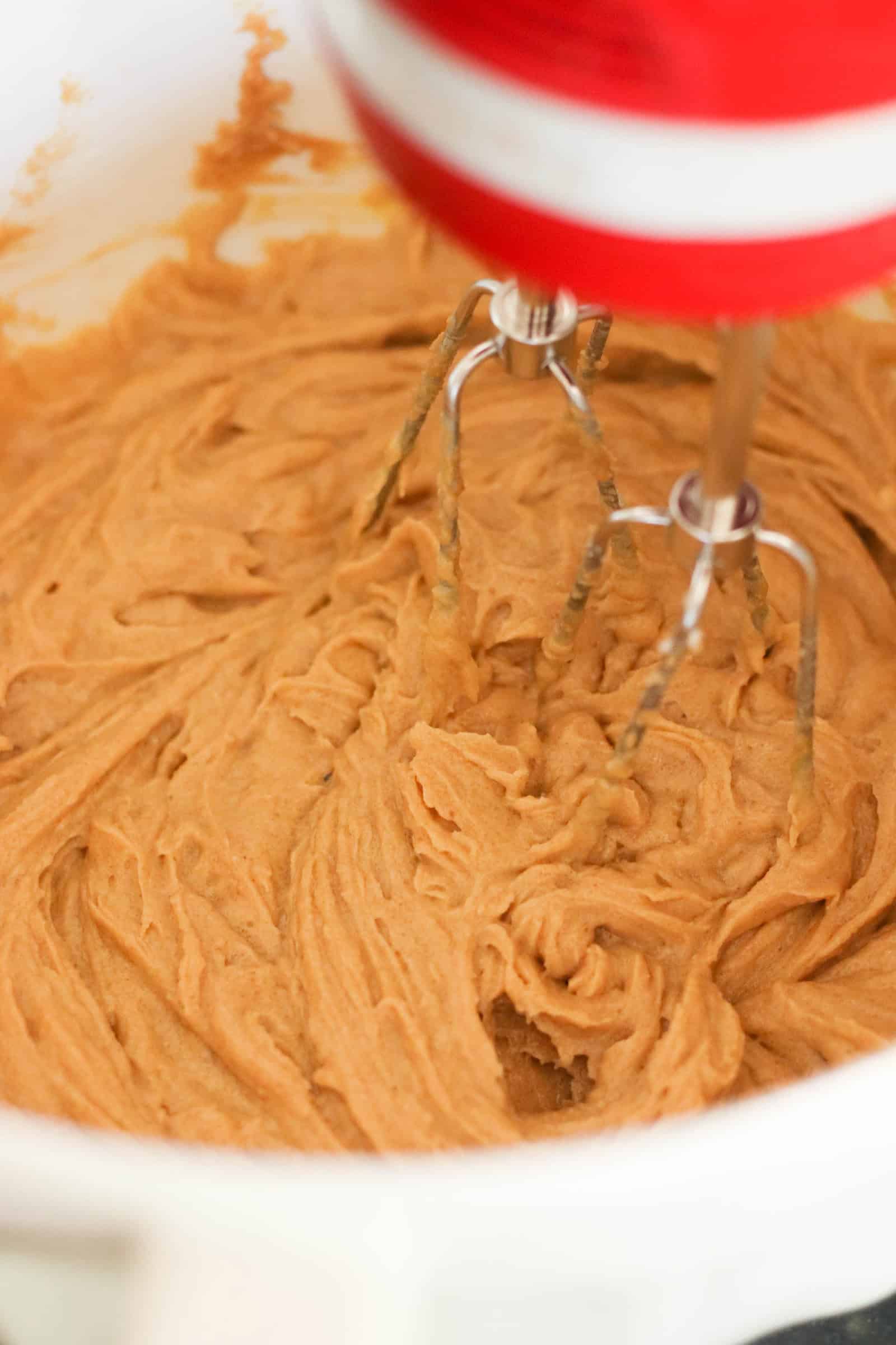 Hand mixer mixing cookie dough ingredients in bowl