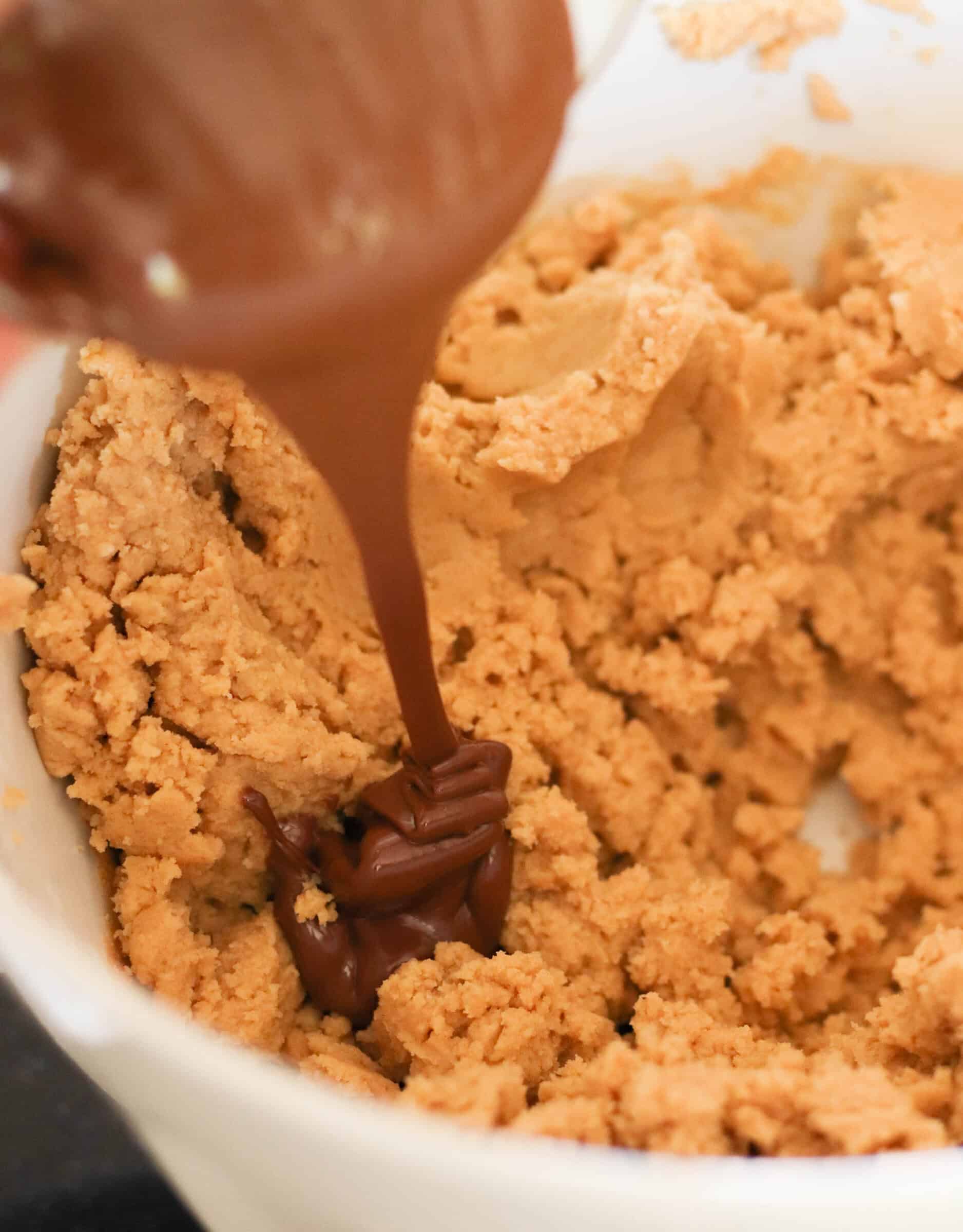 Pouring nutella into cookie dough mixture