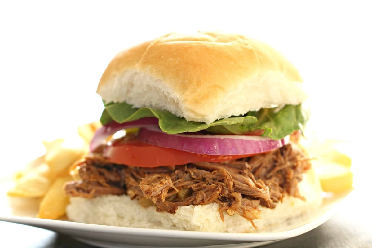 Pineapple BBQ Beef Sandwich on a white plate with a side of fries.