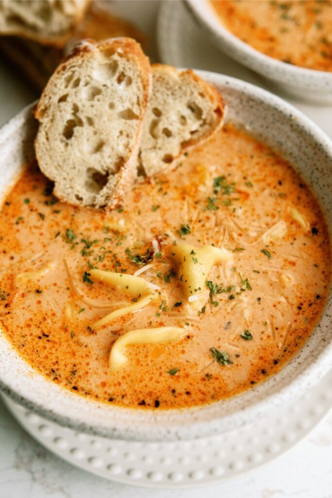 Tomato Tortellini Soup in a bowl with bread on the side
