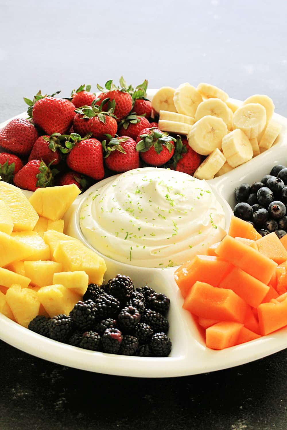 Creamy Lime Fruit Dip served with fruit on a white platter