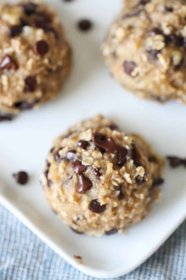 Top view of 3 Skinny Banana Cookies on a plate with mini chocolate chips around them.