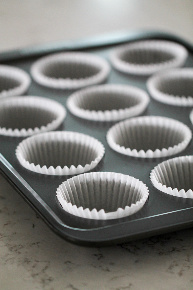 Muffin Tin with muffin paper cups in it.