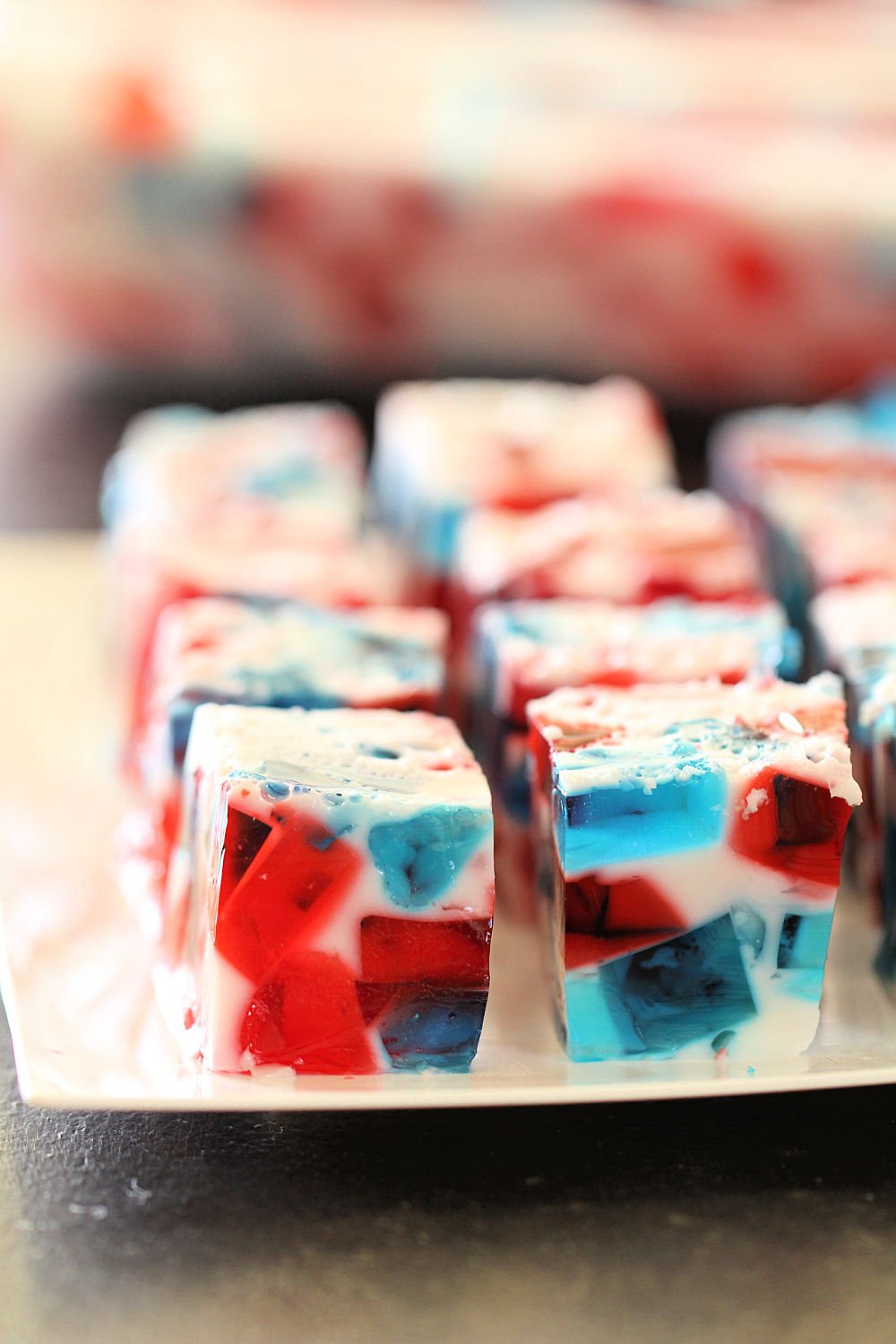 4th of July Jello Recipe cut into squares on a white serving plate