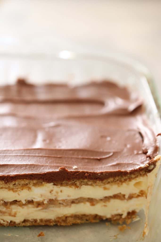 Side view of No Bake Eclair Cake in clear baking dish.