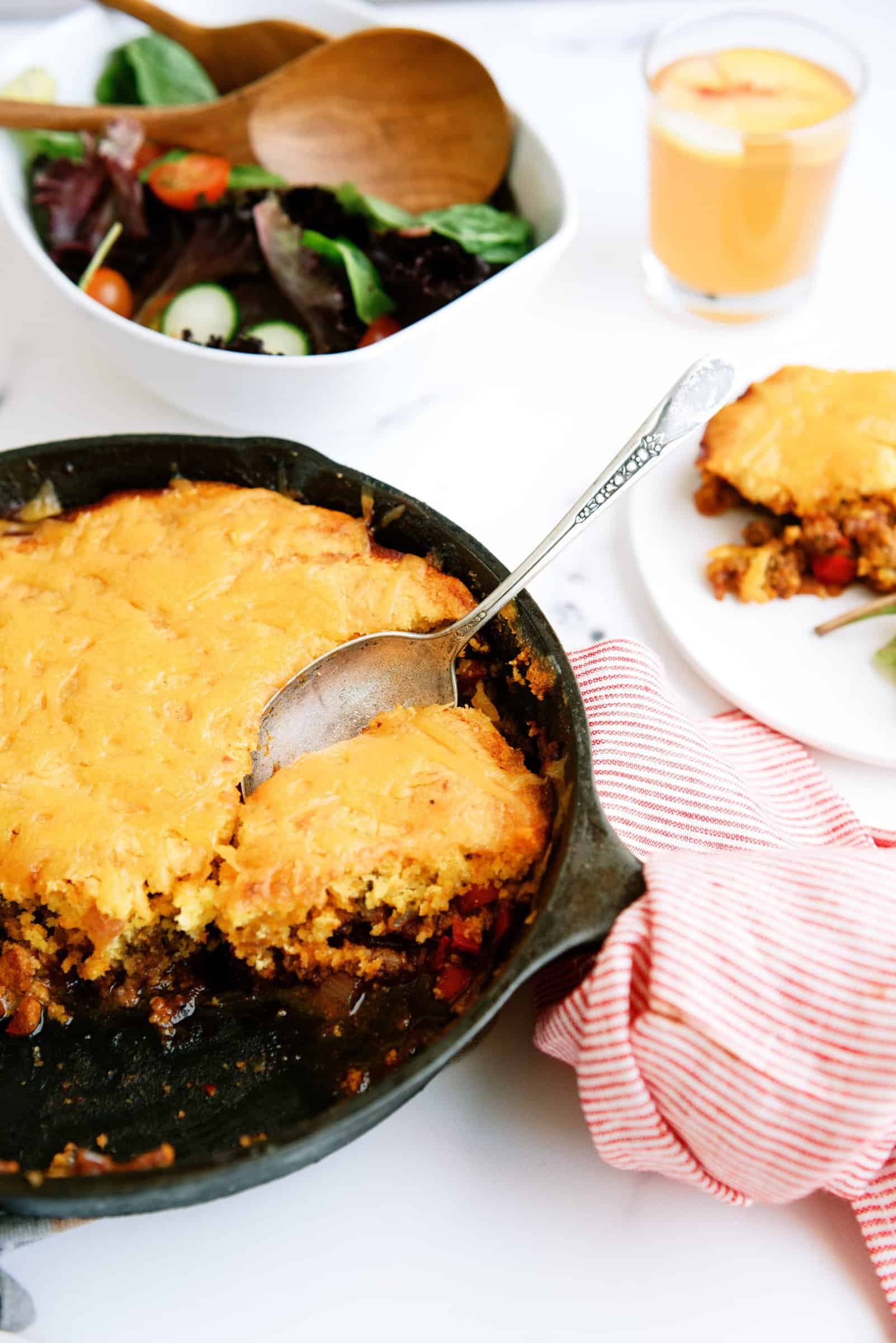 A spoon in the Cornbread Sloppy Joe Casserole skillet