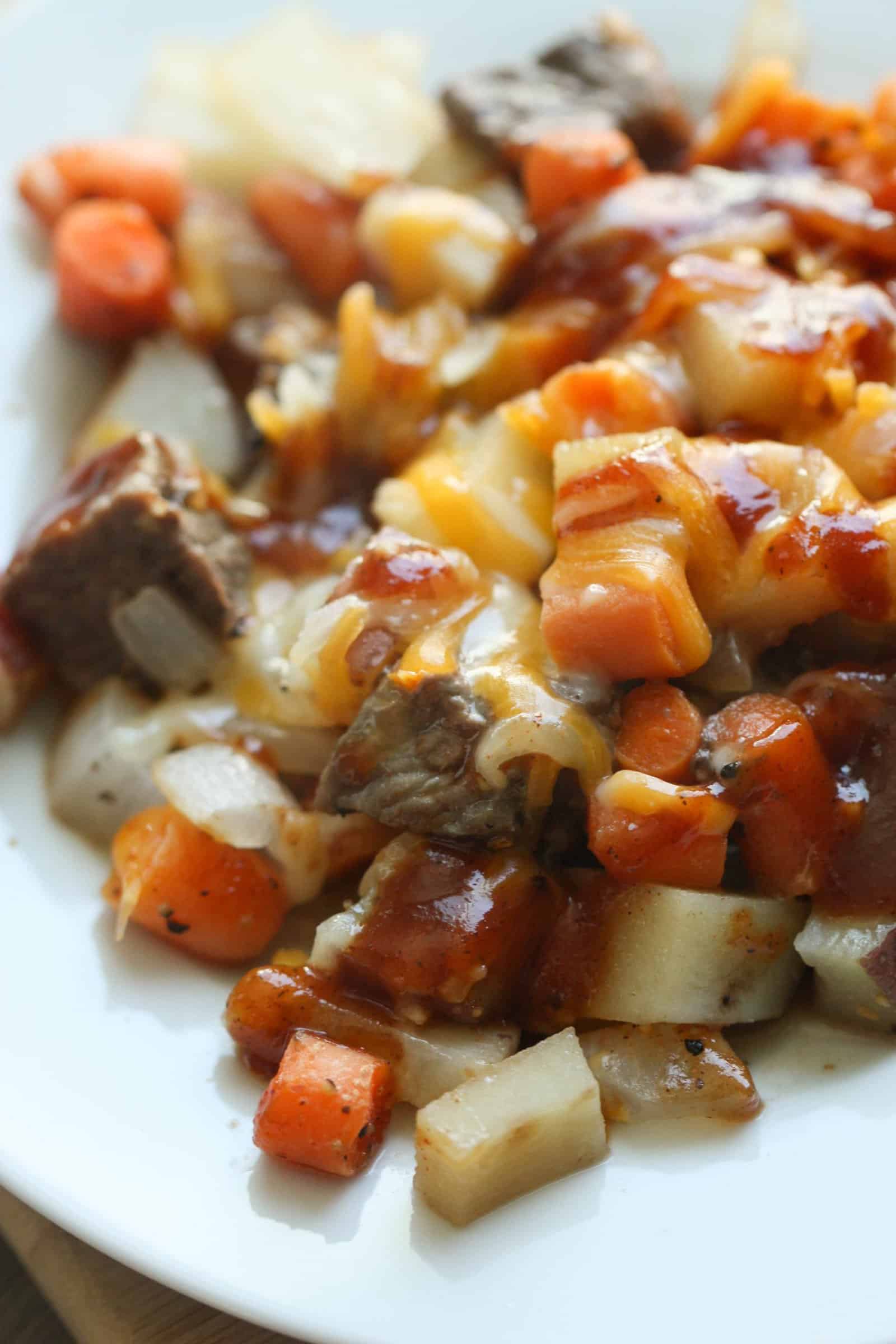 Cooked beef, carrots, potatoes and onions on a piece of foil
