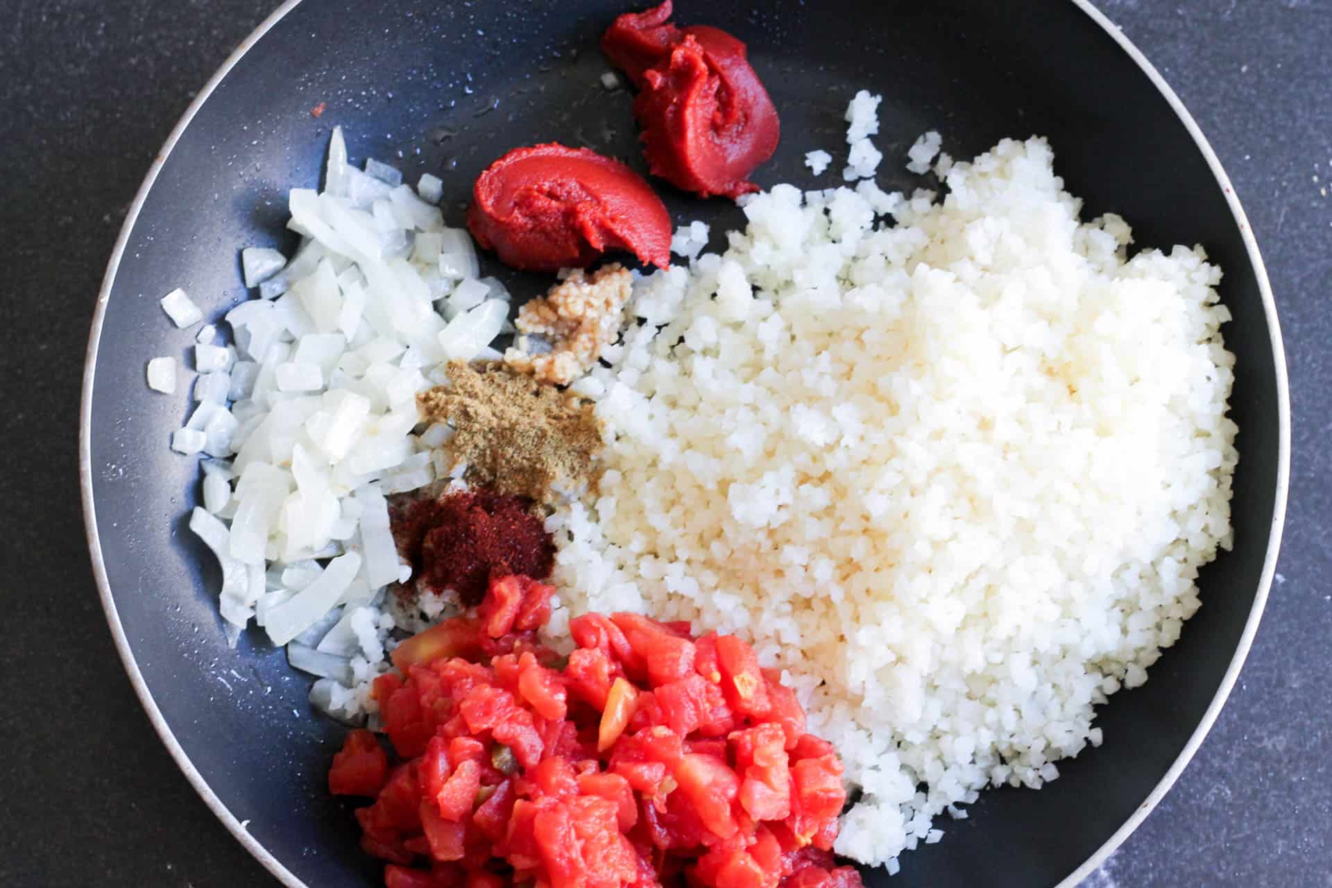 Ingredients for Spanish Cauliflower Rice in skillet