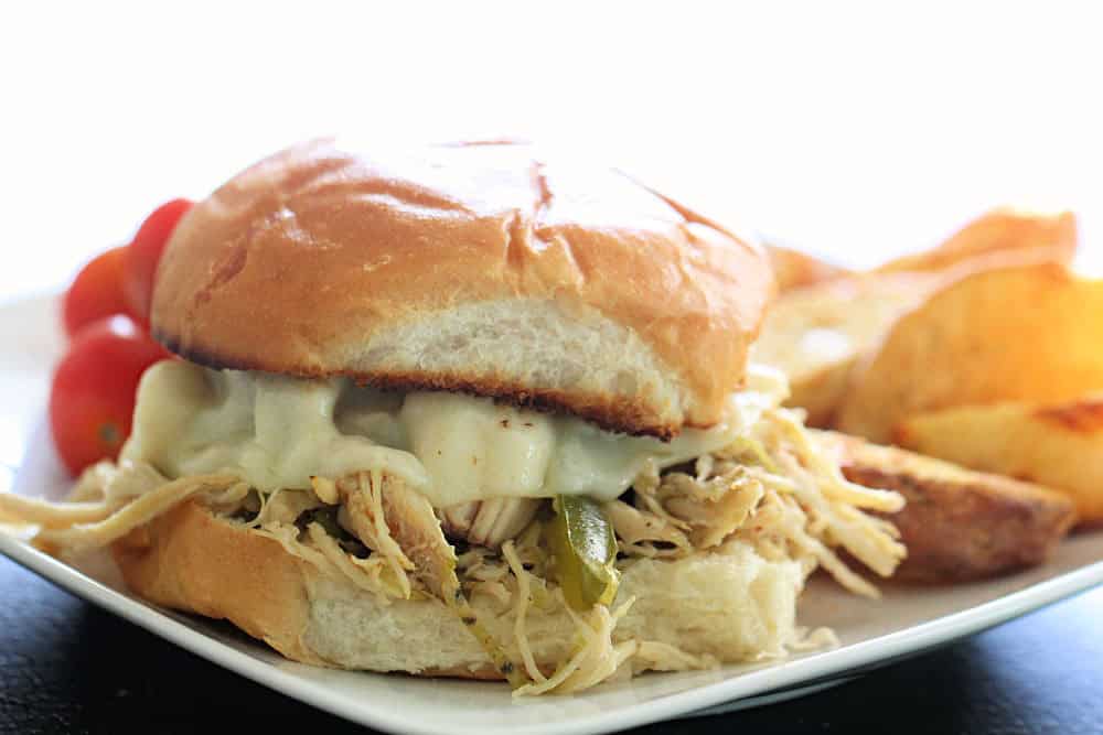 Slow Cooker Chicken Philly Cheesesteak Sandwich on a white plate with chips
