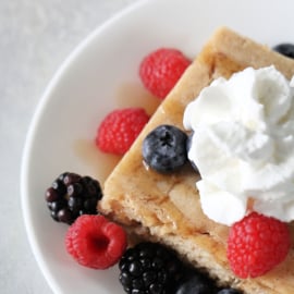 baked pancakes with whipped cream and berries on top