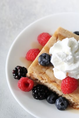 baked pancakes with whipped cream and berries on top