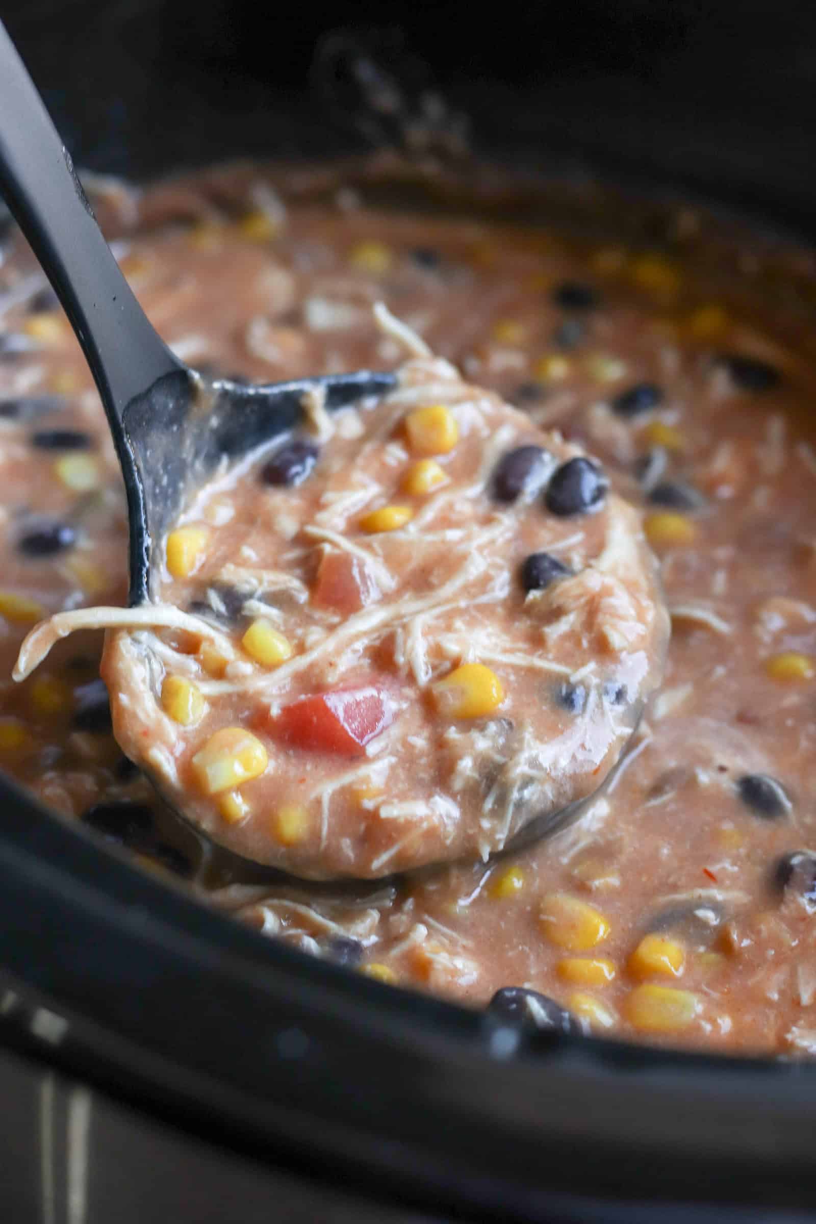 Slow Cooker Creamy Chicken Fajita Soup in the slow cooker with a serving spoon