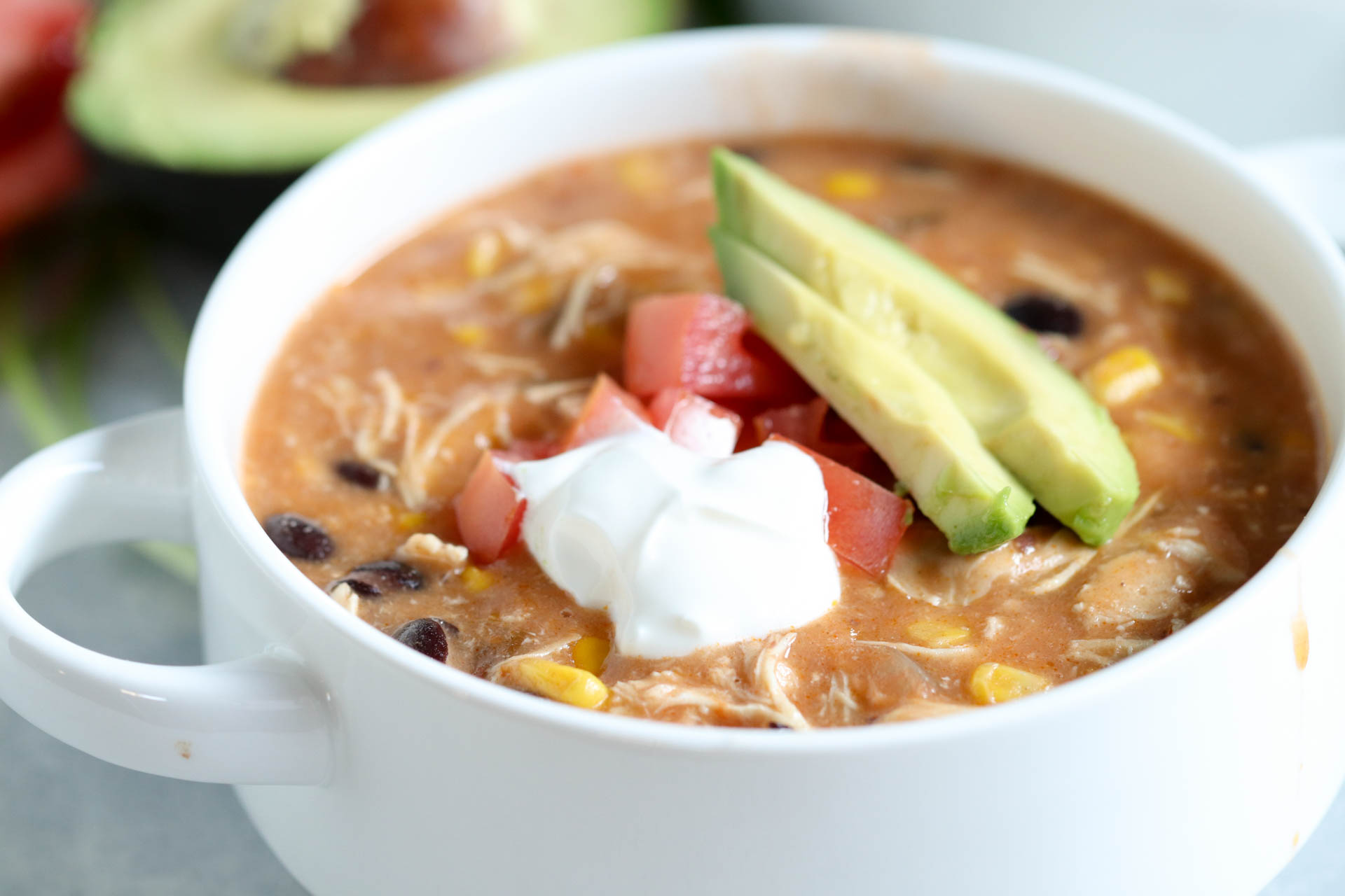 A bowl of Slow Cooker Creamy Chicken Fajita Soup with toppings