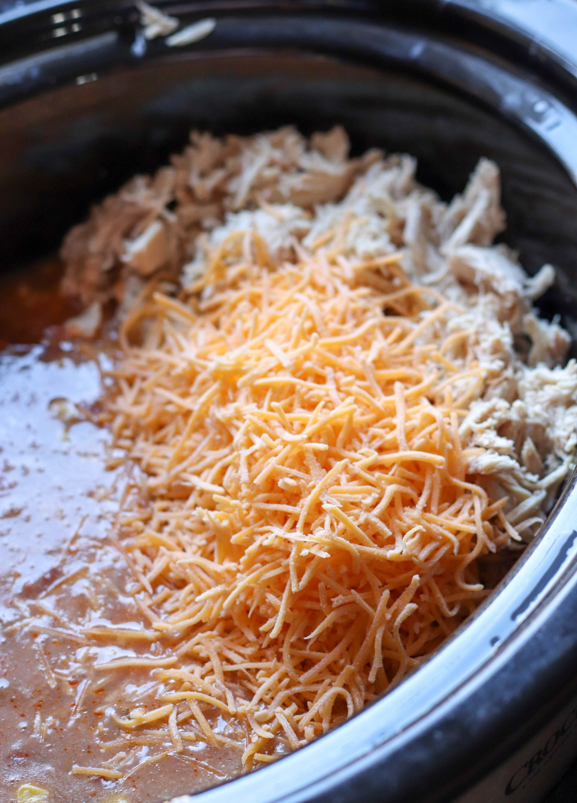 Adding cheese and shredded chicken to slow cooker