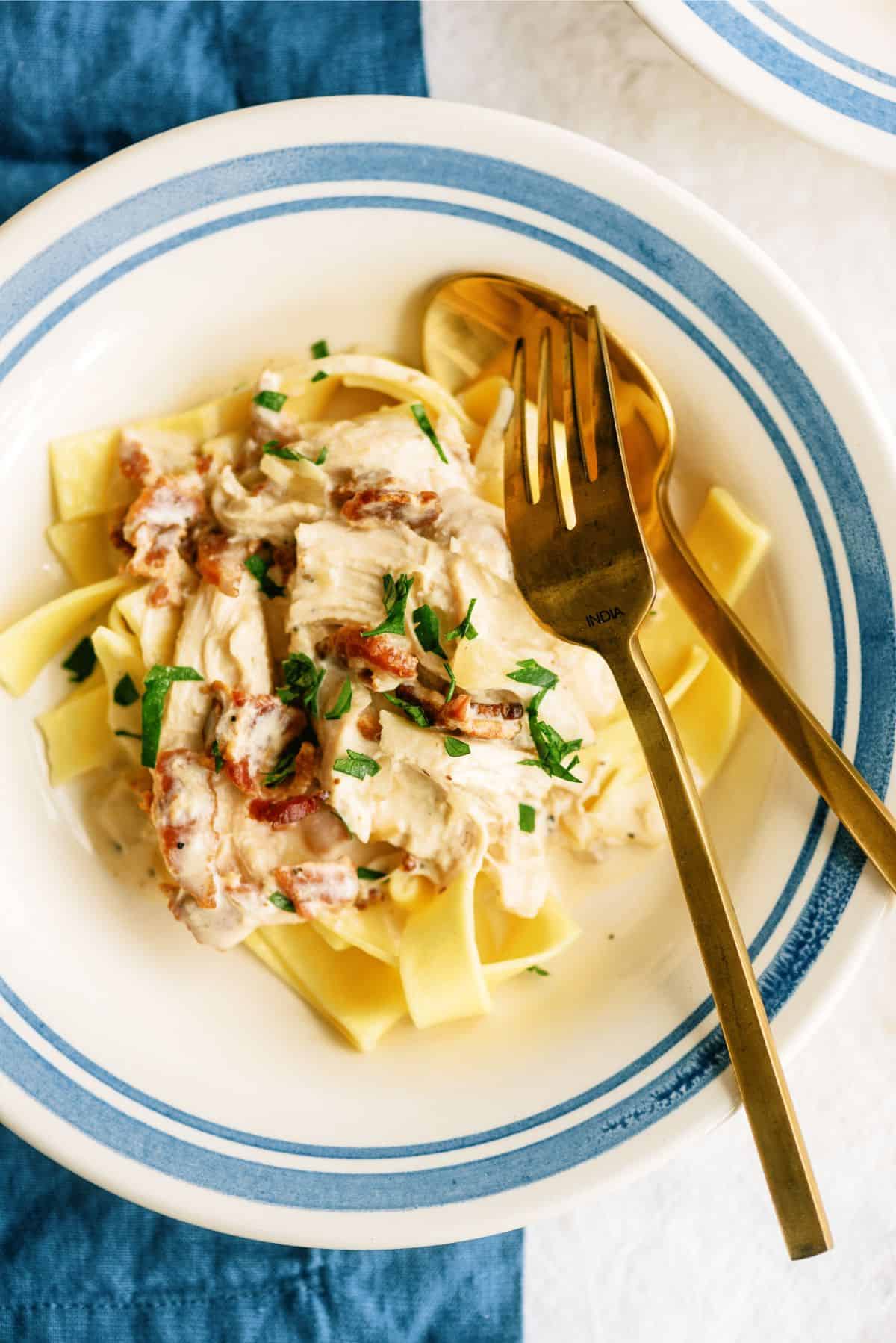 Slow Cooker Creamy Bacon Chicken on top of noodles in a bowl