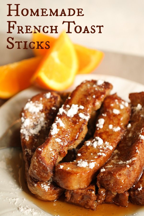 Homemade French Toast Sticks on a plate topped with powder sugar and syrup