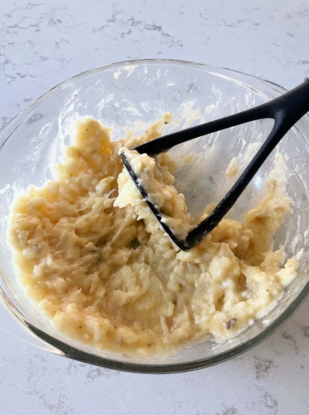 Mashed bananas in a mixing bowl