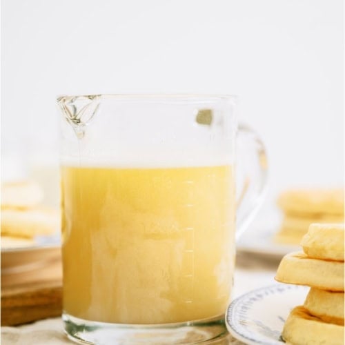 Buttermilk Syrup in a small pitcher with waffles on the side.