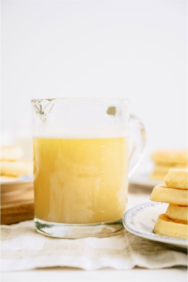 Buttermilk Syrup in a small pitcher with waffles on the side.