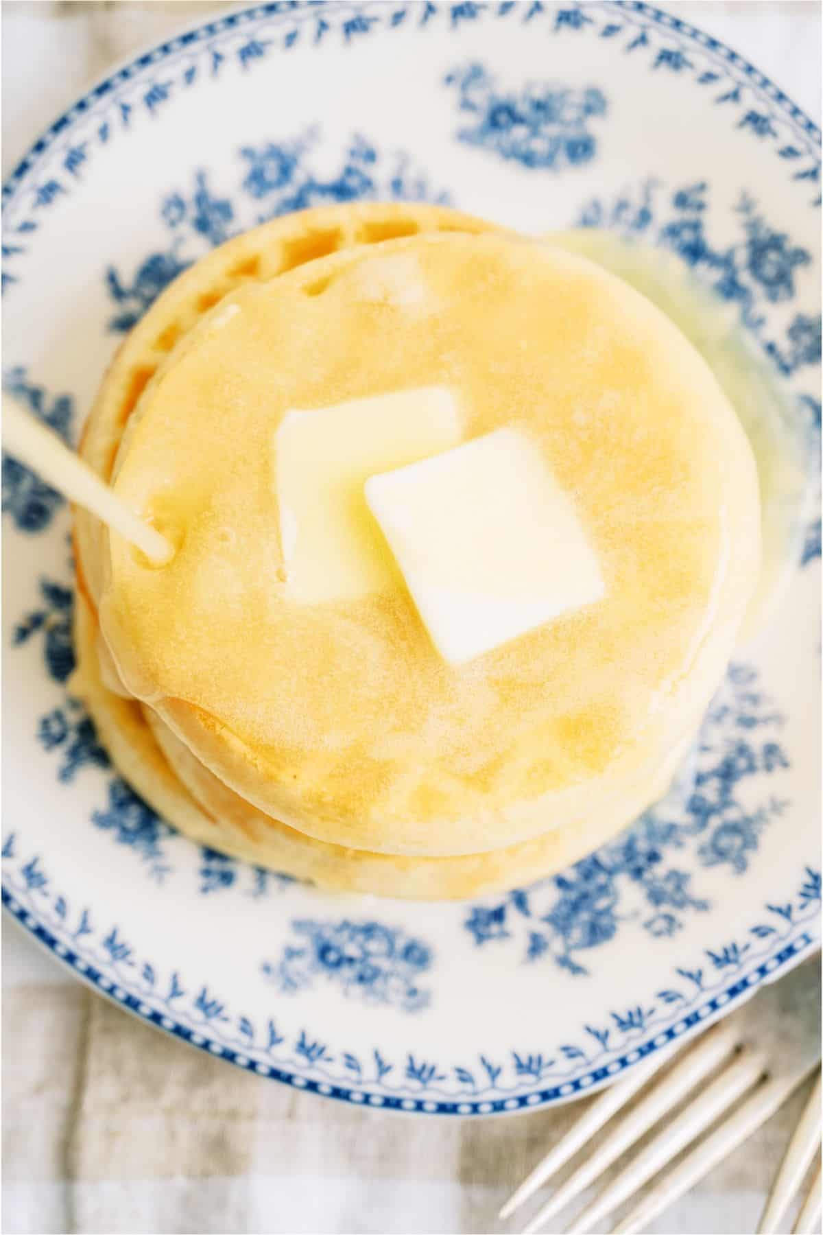 Top view of a stack of waffles with Buttermilk Syrup being poured on top.