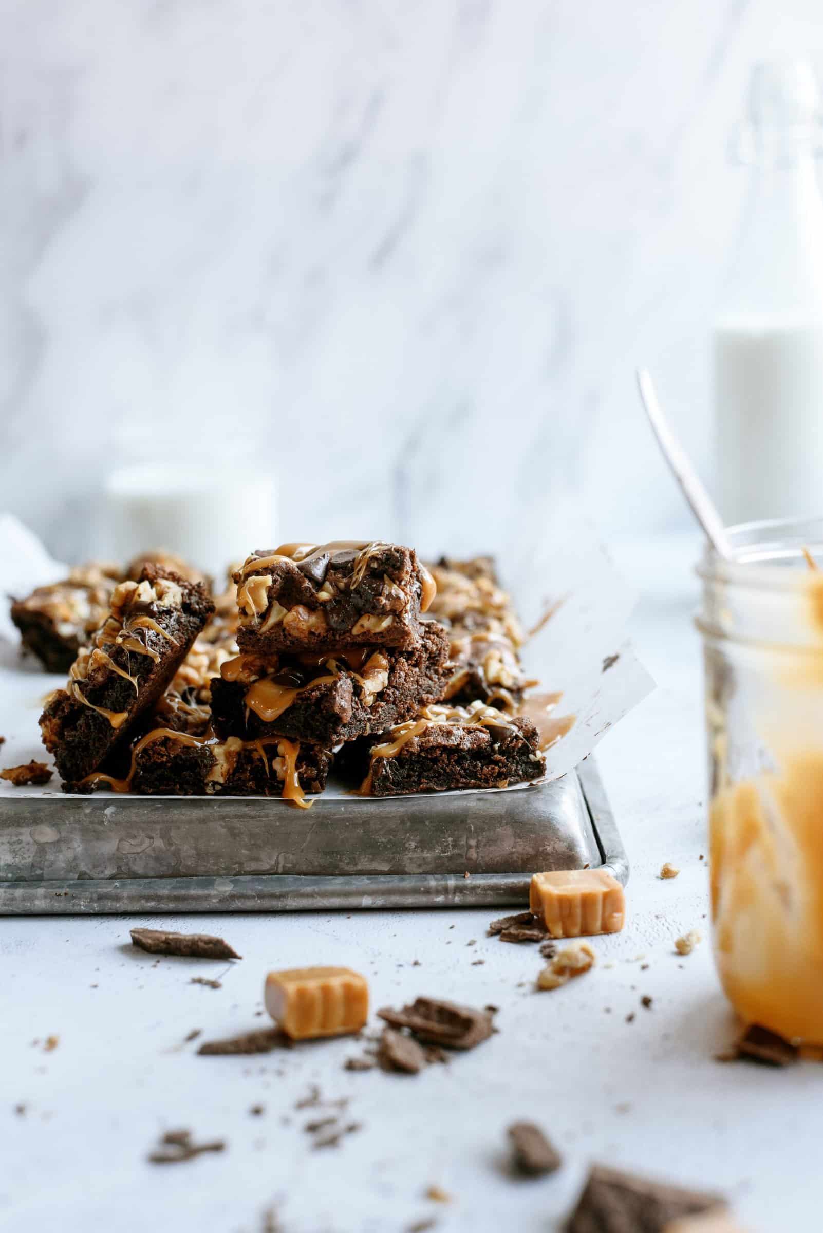 Chocolate Turtle Brownies on a pan with caramel and chocolate shavings