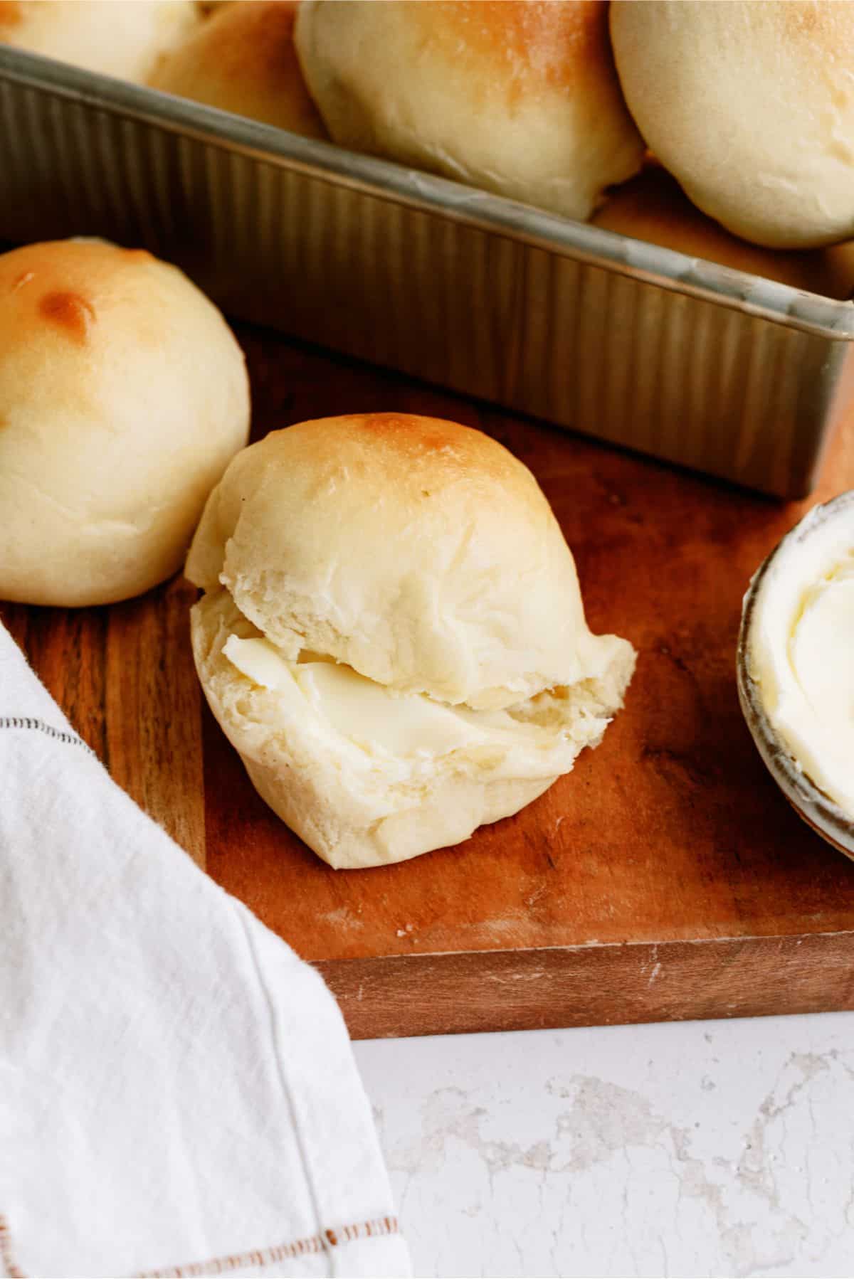 Homemade Potato Rolls with one cut in half with butter on it