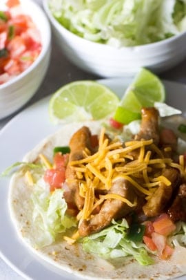 Plated Honey Pork Tacos topped with shredded cheese