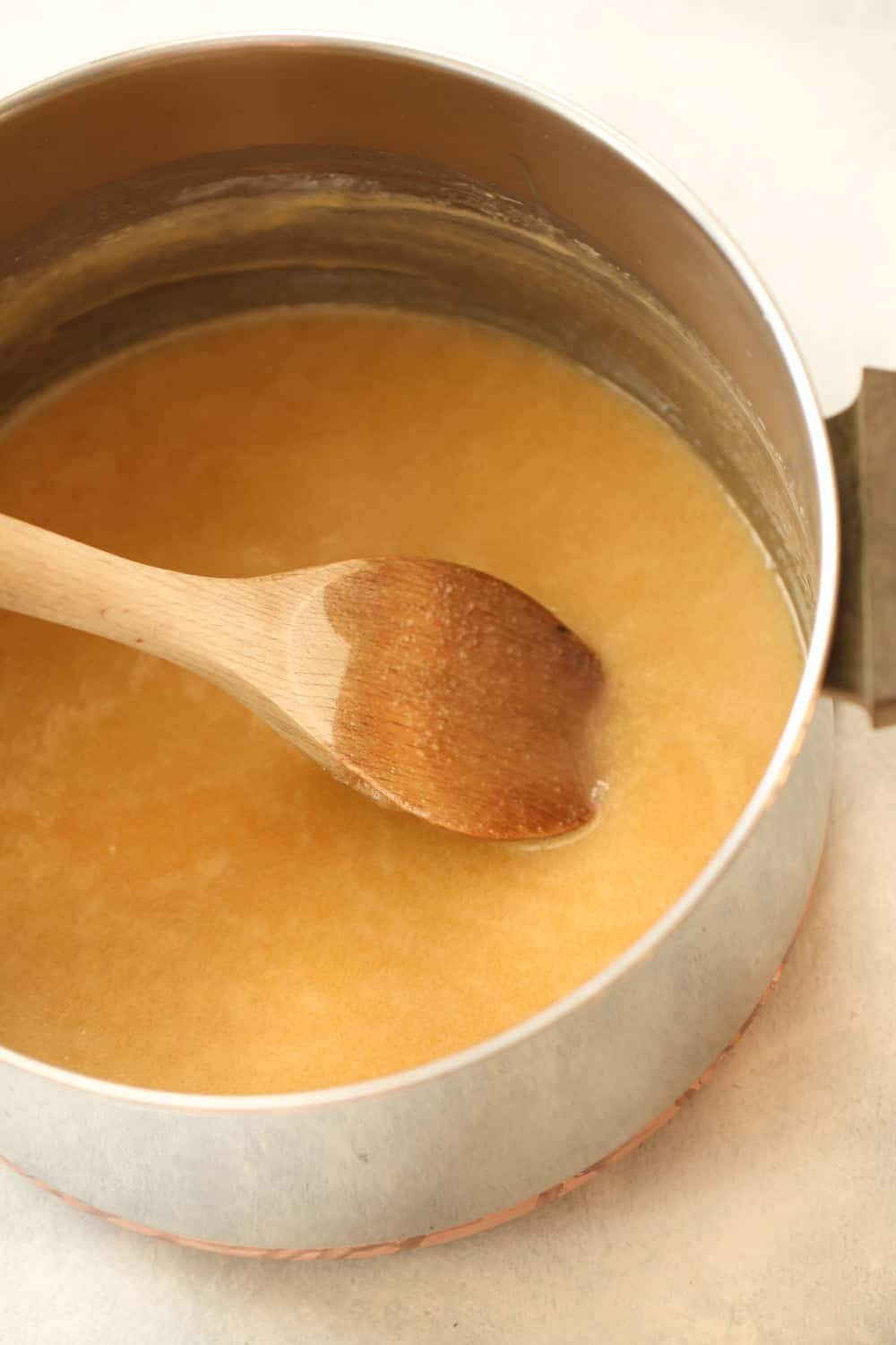 Sugar, evaporated milk, marshmallows, and margarine being stirred together in a sauce pan