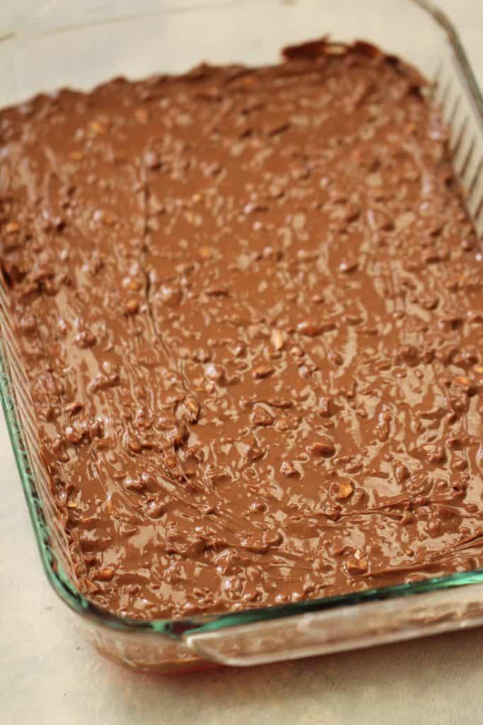 Chocolate peanut mixture spread on top of cherry mixture in baking dish.