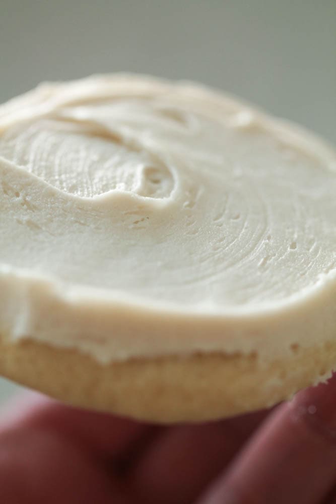 A Vanilla Cookies topped with white frosting.