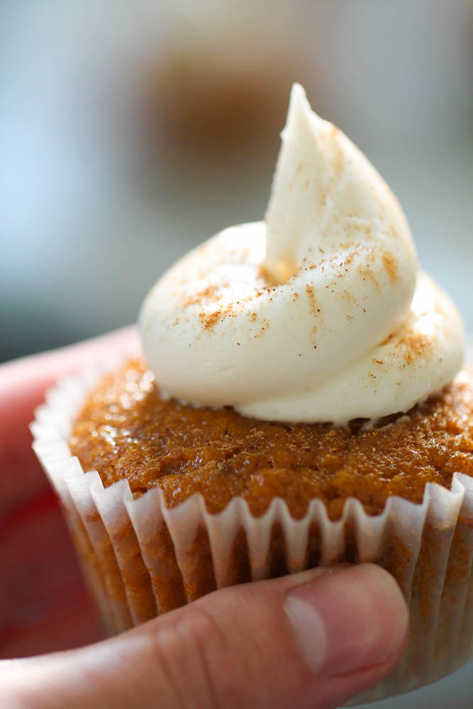 Holding a Pumpkin Pie Cupcake with cream cheese frosting
