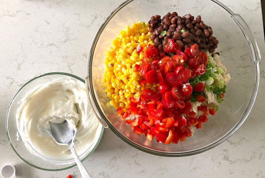 diced veggies in a mixing bowl and greek yogurt mixture in a smaller mixing bowl