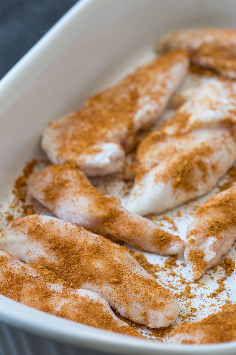 Raw chicken with seasoning in an 9x13 pan