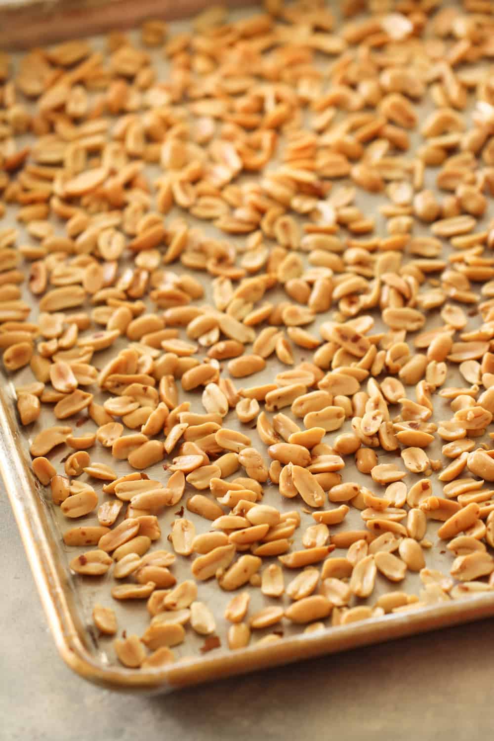 Sheet pan with peanuts spread all over the bottom