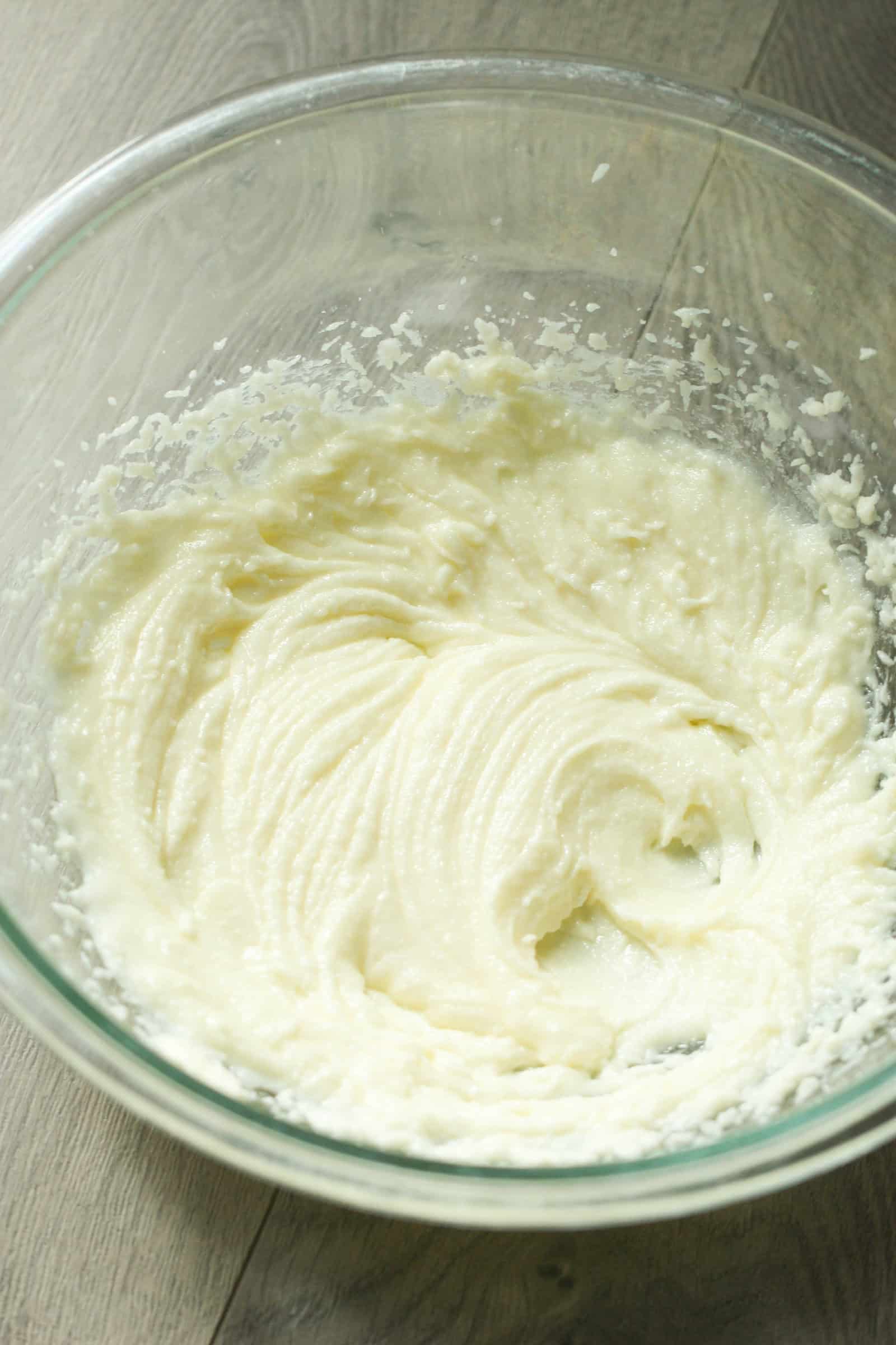 Glass mixing bowl with butter and sugar mixed together