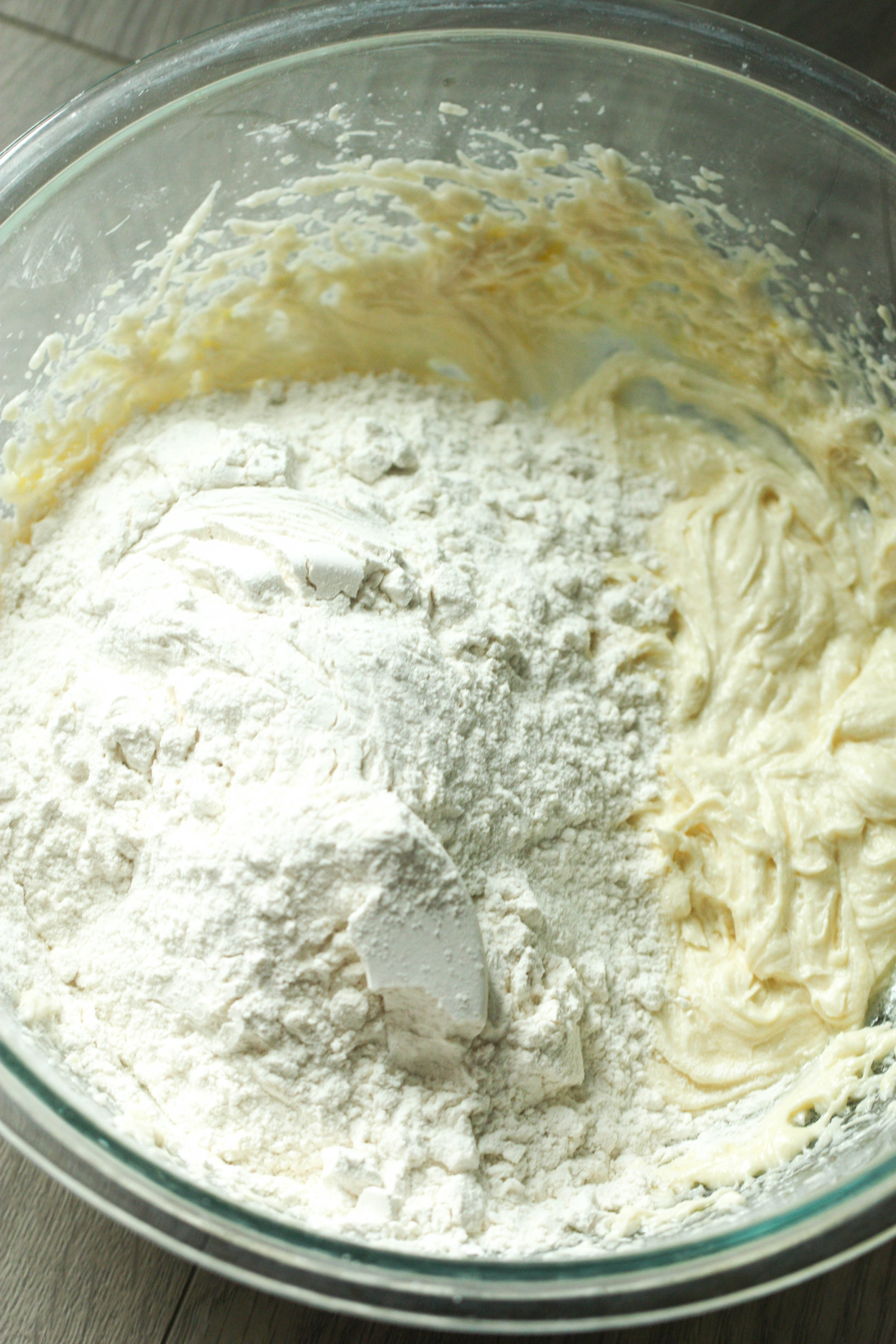 Flour added to the butter sugar mixture in the mixing bowl