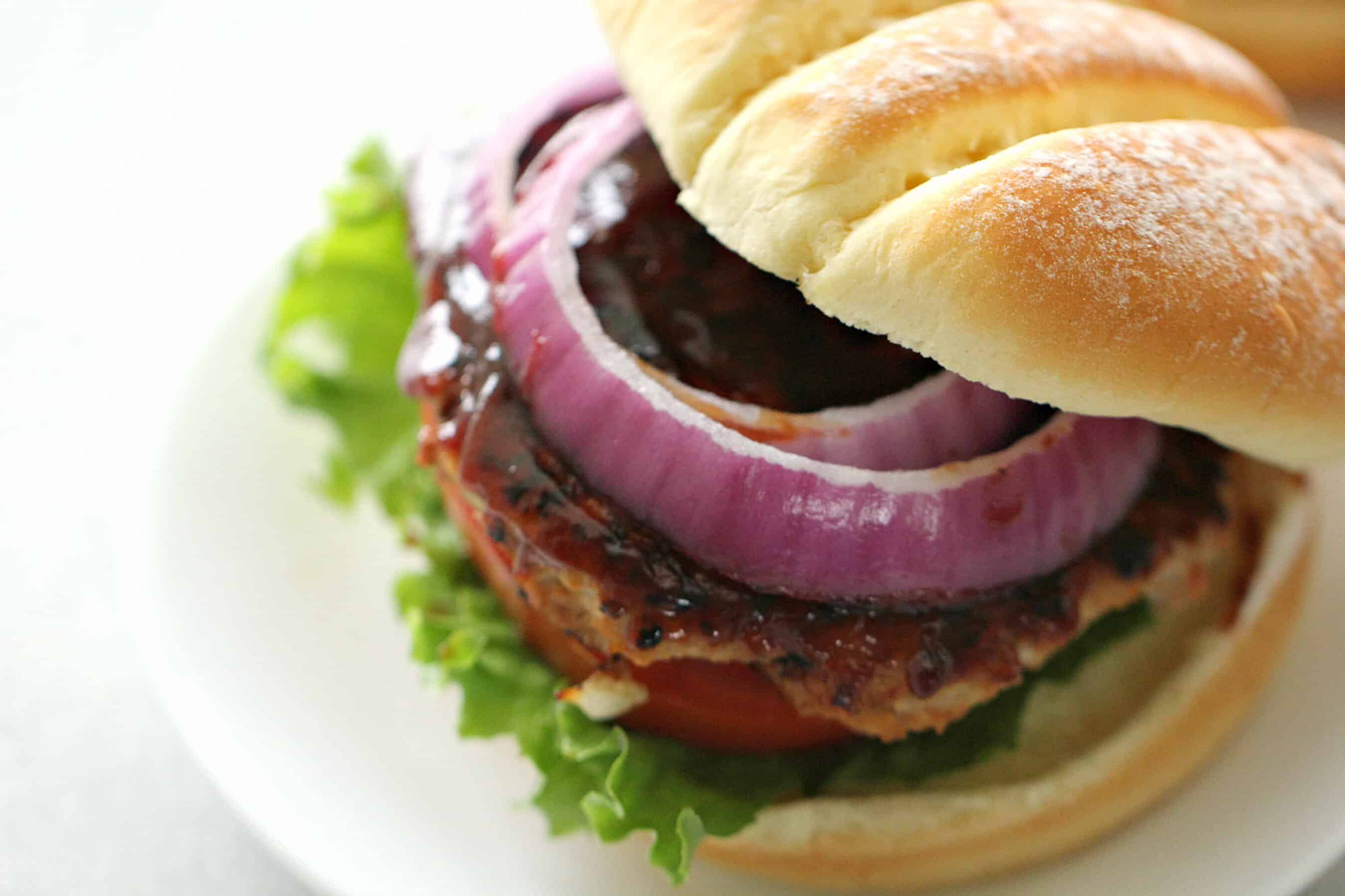 BBQ Turkey Burger on bun with toppings served on a white plate