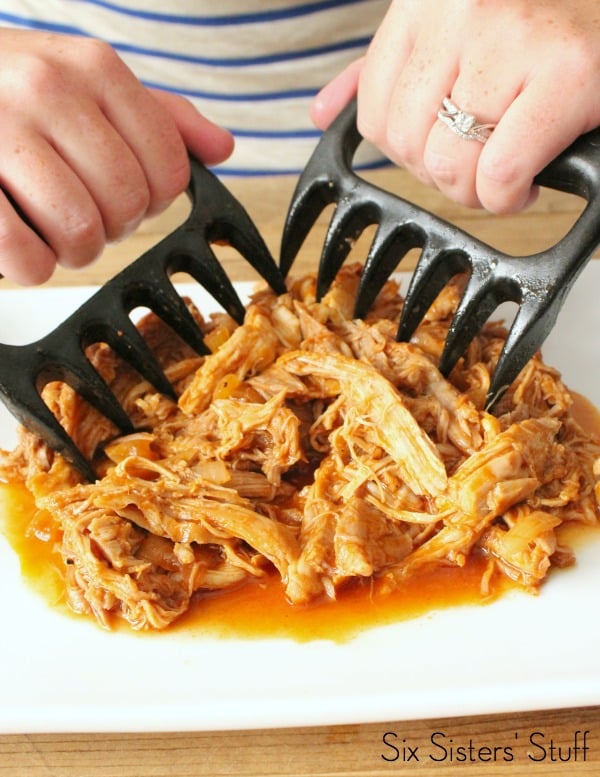 Chipotle Pulled Pork on a cutting board being shredded with bear paws