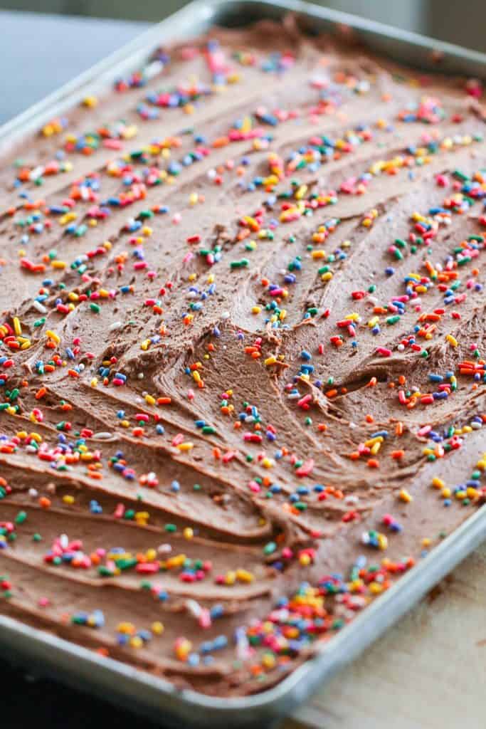 Frosted Chocolate Sugar Cookie Bars with sprinkles in baking sheet.