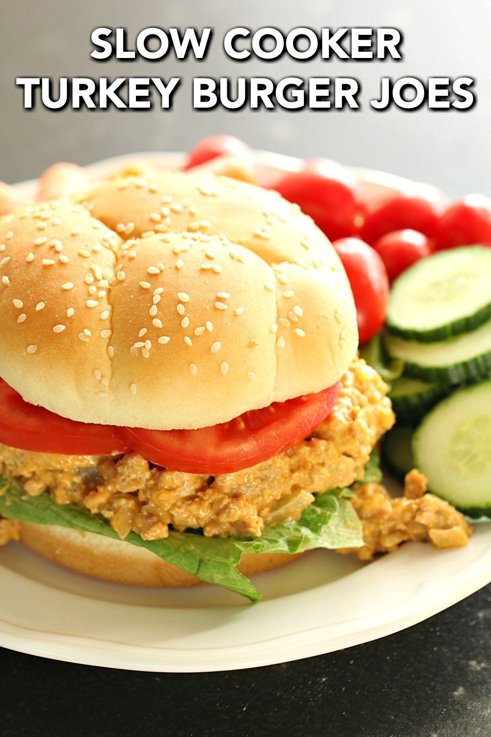 Slow Cooker Cheesy Turkey Burger Joes on a bun plated with vegetables