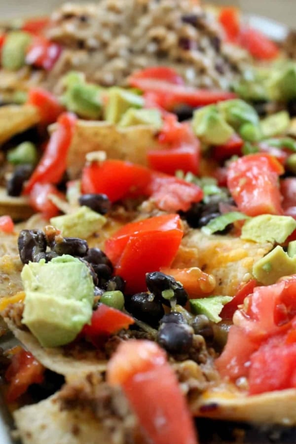 baked nachos with avocado, tomato, and olives