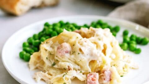 chicken cordon blue with potatoes and peas on a plate